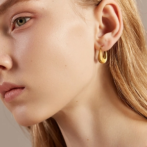 Boucles d'oreilles créoles dorées en forme de U au fini métallique satiné moderne