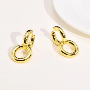 Close-up of interlocking gold geometric hoop earrings with polished metallic finish