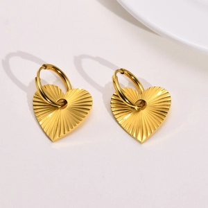 Golden heart earrings with radial textured patterns and minimalist round ear clasps