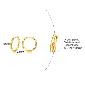 Détail de la texture martelée polie sur les boucles d'oreilles créoles dorées de 21 mm