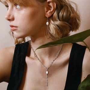 Model wearing stainless steel freshwater pearl necklace and matching drop earrings set