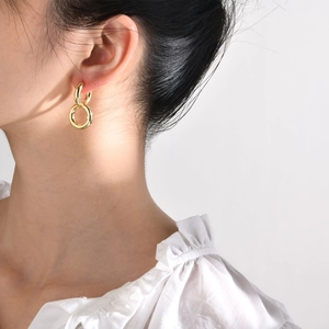 Elegant gold double interlocking circle earrings featuring high-polish finish on a model