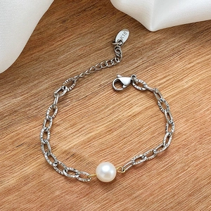 Detail of stainless steel textured oval link bracelet featuring a white freshwater pearl