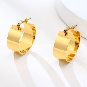 Macro view of wide gold-plated stainless steel hoop earrings with high-polish finish