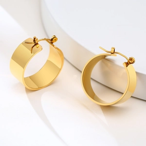 Minimalist wide band gold hoop earrings in polished stainless steel on white stand