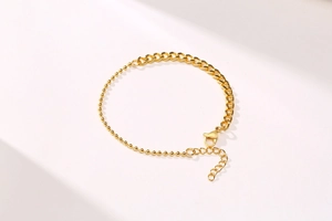 Detail of 18K gold stainless steel bracelet featuring bead and tank chain links