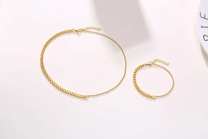 Detail of 18K gold stainless steel set featuring curb and bead chain link necklace