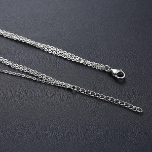 Détail d'un collier multicouche en acier inoxydable argenté avec fermoir mousqueton et rallonge