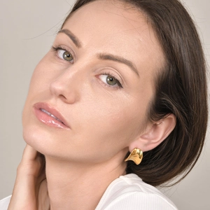 Minimalist gold irregular C-shaped earrings with polished finish on model's ear