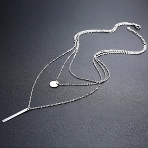 Vue détaillée du collier triple épaisseur en acier argenté avec pendentifs géométriques