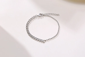 Detail of silver dual-design bracelet featuring cuban links and smooth bead chain texture