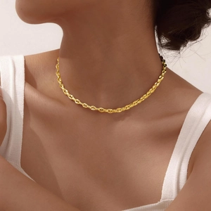 Dettaglio della collana a catena intrecciata dorata indossata con trama fine
