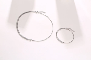 Detail of silver stainless steel curb and bead chain jewelry set with lobster clasp closure