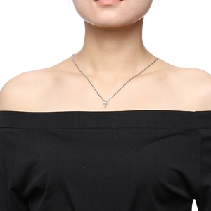 Close-up of minimalist silver cross pendant on thin O-chain worn by a model