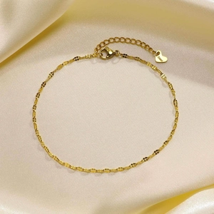 Close-up of golden stainless steel lip chain with lobster clasp and heart charm
