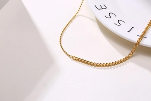 Detail view of 18K gold stainless steel necklace featuring mixed ball and curb chain design