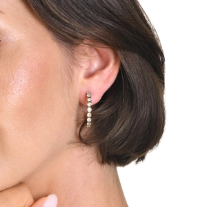 Details von 18k vergoldeten C-Ohrringen mit Zirkonia, getragen von einem Modell
