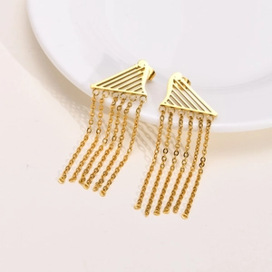 Detail of gold geometric triangle tassel earrings with multiple chains on a ceramic plate