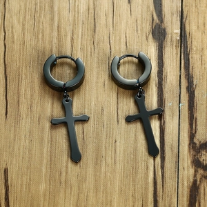 Minimalist black stainless steel cross earrings for men and women on a wooden background