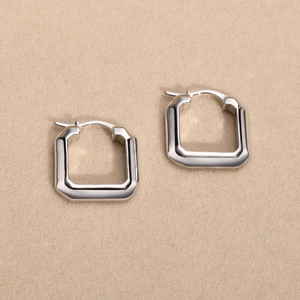 Macro shot of polished square geometric hoop earrings in a minimalist metal design