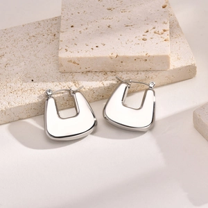 Détail macro de boucles d'oreilles en acier inoxydable argenté en forme de U sur pierre