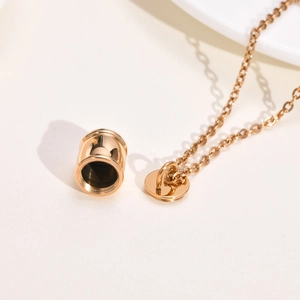 Détail du collier funéraire en or rose avec un pendentif cylindrique à vis