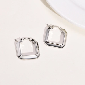 Close-up of geometric square silver hoops with a polished metallic finish on a white background