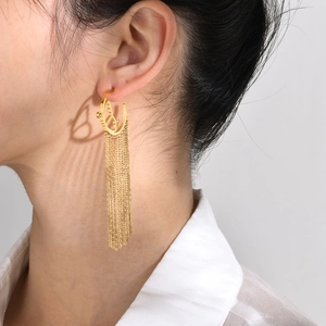 Close-up of gold stainless steel butterfly earrings with long tassel chains on a model