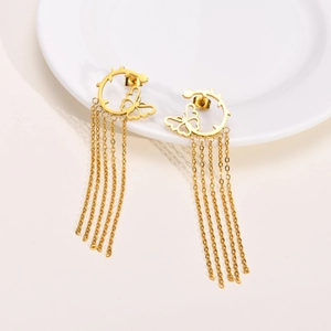 Detailed macro view of golden stainless steel hoop earrings with hanging butterfly tassels