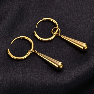 Detailed view of polished golden teardrop earrings on black satin background