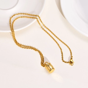 Détail d'un collier pendentif cylindre doré poli sur des assiettes en porcelaine