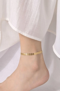 Elegant gold heart-link ankle bracelet for women shown worn with a white dress