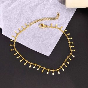 Close-up of a gold stainless steel anklet with multiple small rectangle paddle pendants