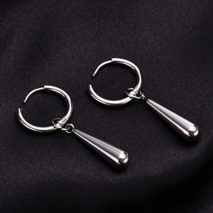 Close-up of silver stainless steel water drop earrings on a black silk background