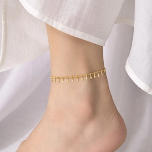 Detailed close-up of a minimalist golden stainless steel anklet with rectangular charms