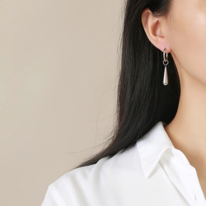 Polished silver stainless steel drop earrings shown on model for length and fit detail