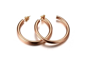 Détail de boucles d'oreilles créoles en acier titane or rose avec finition polie