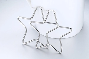 Macro detail of polished stainless steel star hoop earrings with mirror finish