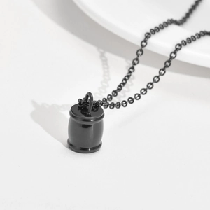 Vue détaillée d'un collier urne cylindrique en acier inoxydable noir sur fond minimaliste
