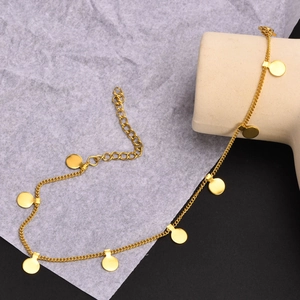 Close-up of a gold titanium steel anklet with flat round sequin charms and adjustable chain