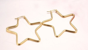 Detailed view of gold star-shaped hoop earrings with polished finish and stud closures