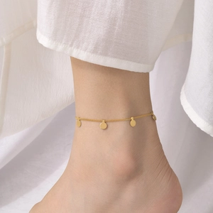 Close-up of a gold-plated stainless steel anklet with delicate round disc charms