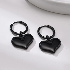 Détail des boucles d'oreilles créoles coeur en acier inoxydable noir sur fond minimaliste