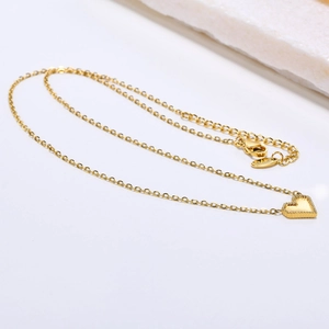 Detailed macro view of gold heart pendant necklace with S925 hallmark and cable chain