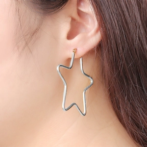 Polished silver stainless steel star hoop earrings shown in a side-profile ear piercing view