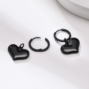 Détail des boucles d'oreilles cœur noires avec une finition métallique polie