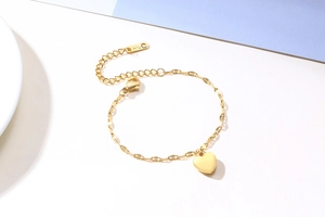 Macro detail of gold heart pendant with K18 engraving on the adjustable chain link