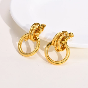 Macro detail of gold layered hoop earrings with high-polish finish and butterfly backs