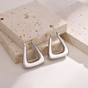 Minimalist silver U-shaped earrings on stone background with premium metallic finish