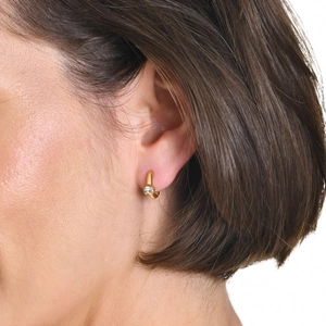 Close-up of 18K gold-plated C-shaped hoop earring with sparkling zircon on ear
